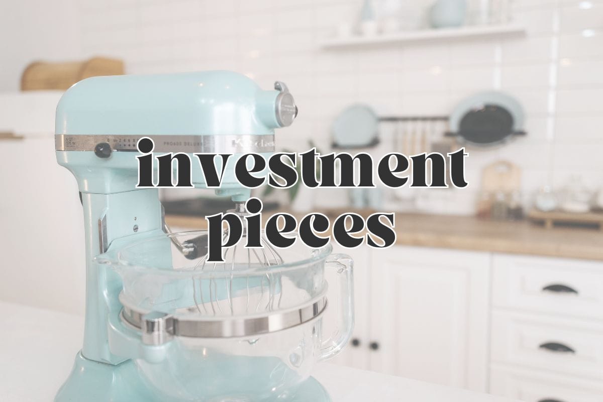Side view, a light blue stand mixer on a counter in a white kitchen; text overlay reads "investment pieces".