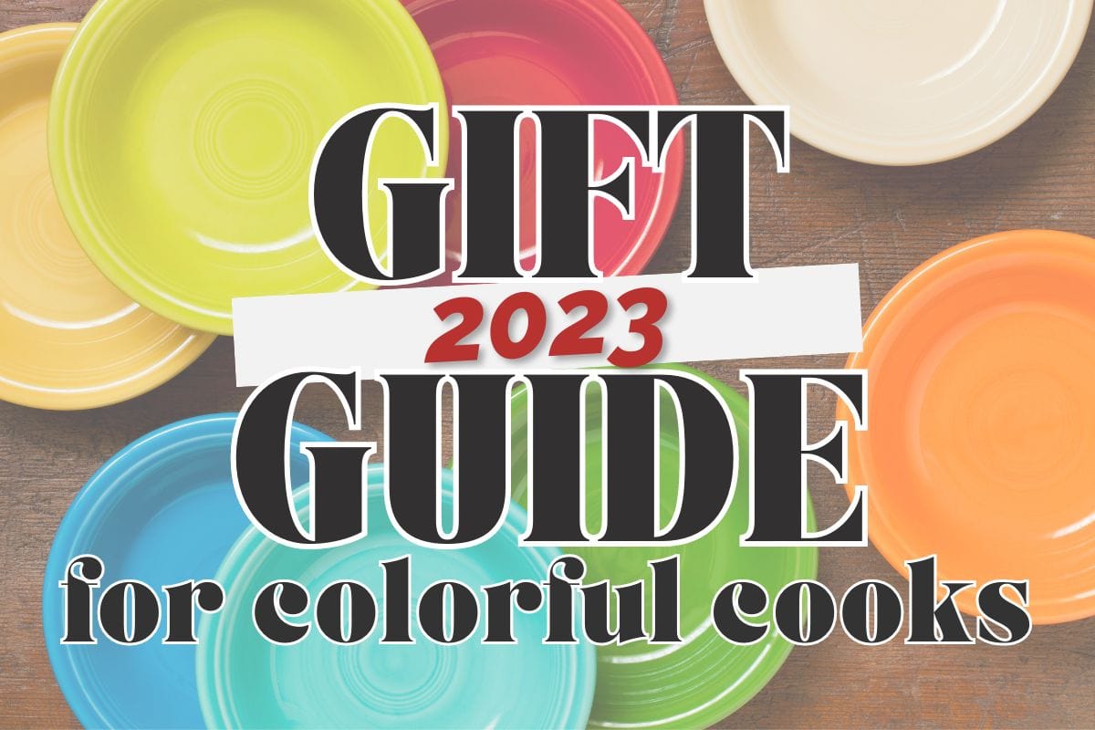 Various bold colored solid plates arranged over a wood background; text overlay reads "2023 gift guide for colorful cooks".