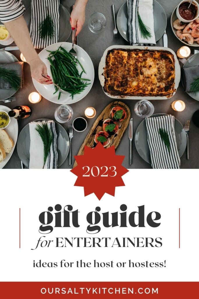 A Christmas table setting with entrees and side dishes, beautiful place settings, and woman's hand serving a side of green beans; text box below reads "2023 gift guide for entertainers".