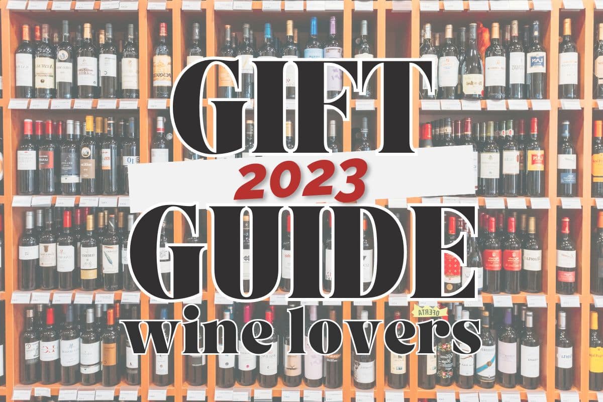 A wall of wines arranged on shelves; text overlay reads "2023 gift guide for wine lovers".