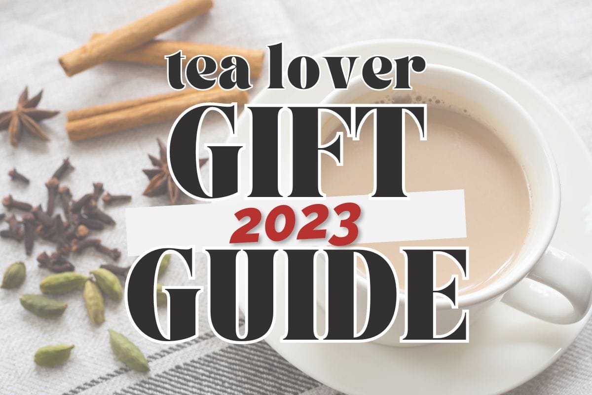 Side view, hot tea in a white teacup on a sauce with whole spices in the background; text overlay reads "tea lover 2023 gift guide".