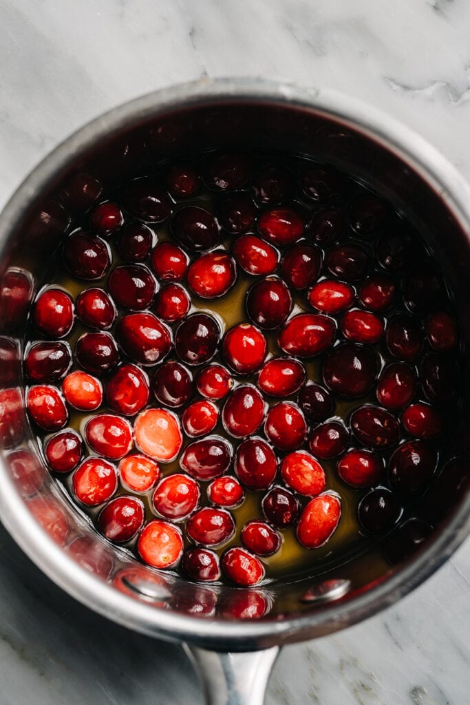 Fresh cranberries, water, and sugar in a small stainless steel saucepan.
