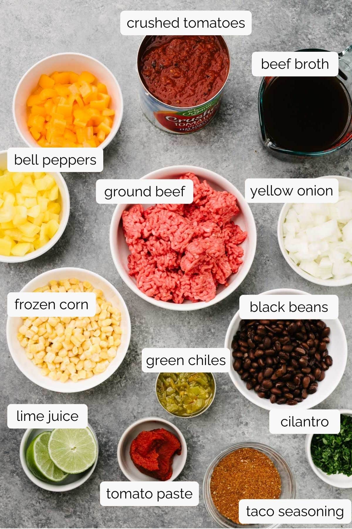 The ingredients for crockpot taco soup in small bowls on a concrete background.