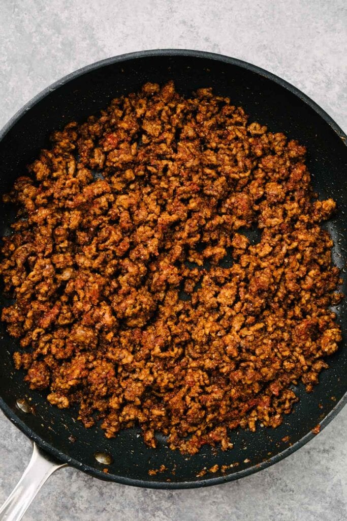 Ground beef cooked with taco seasoning in a skillet.
