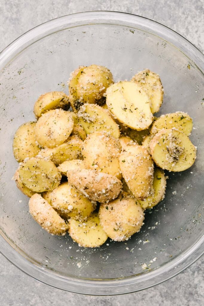 Halved baby yukon gold potatoes tossed with olive oil, garlic powder, Italian seasoning, salt, and grated parmesan cheese.