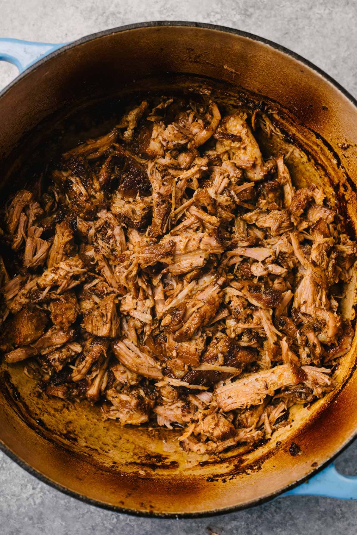 Oven braised pulled pork in a dutch oven tossed in the rendered pan sauce.